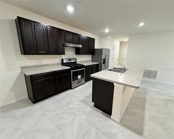 a kitchen with sink cabinets and stainless steel appliances