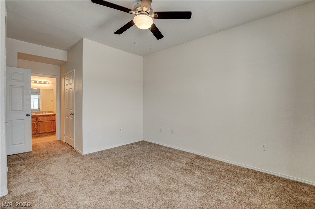 3318 North Decatur Boulevard, Unit 1069 Las Vegas, NV 89130 - Photo 26 of 39 An inviting bedroom with plush carpeting leads to a private, well-appointed bathroom.