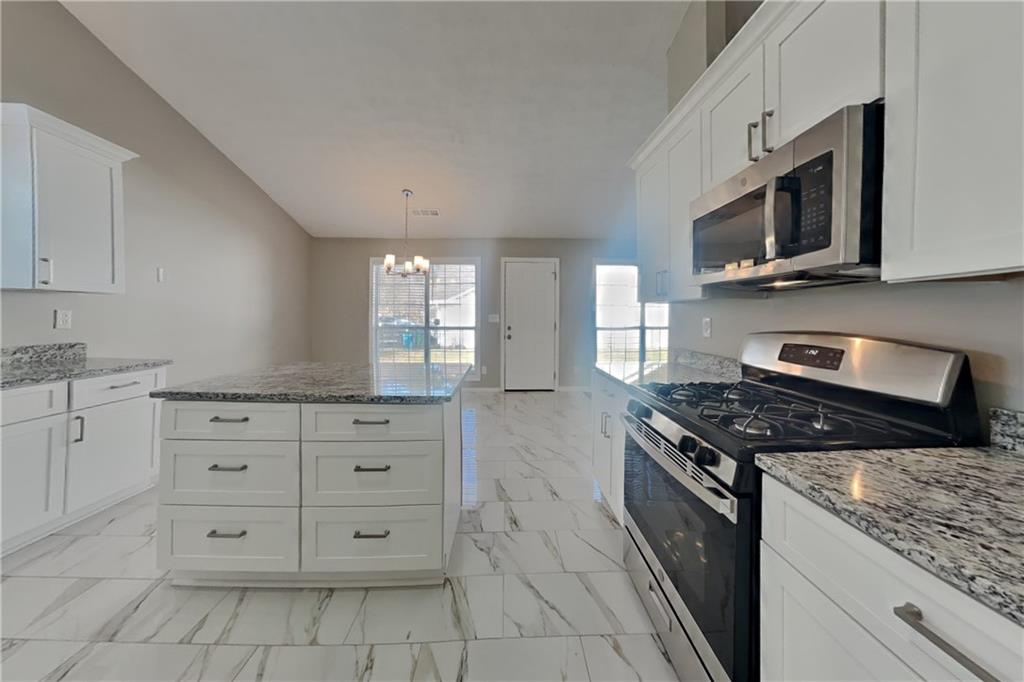 3845 Rajean Drive Lawrenceville, GA 30044 - Photo 4 of 18 a kitchen with stainless steel appliances granite countertop a stove a sink and a microwave
