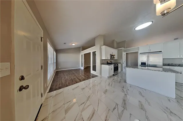 a large white kitchen with white cabinets and stainless steel appliances