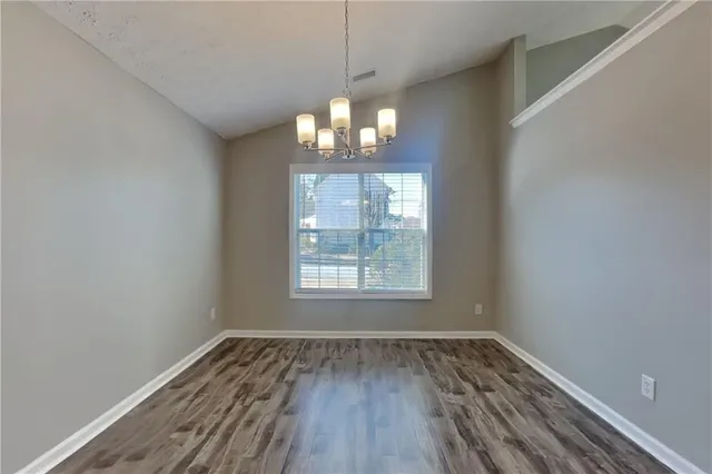 a view of wooden floor chandelier and window in a room