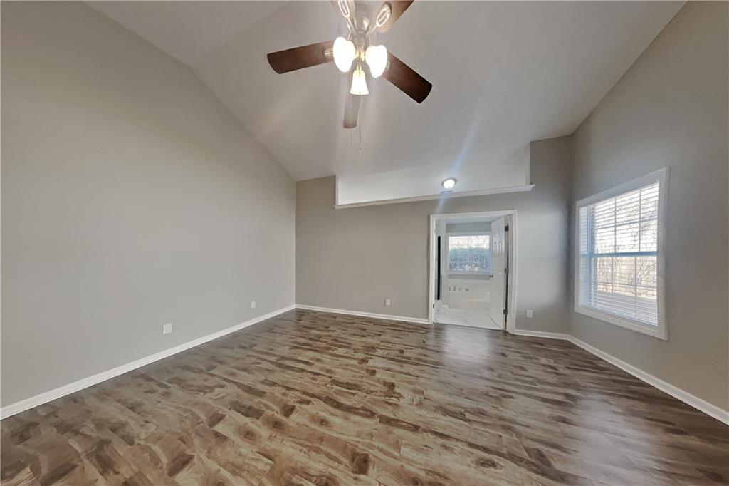 3845 Rajean Drive Lawrenceville, GA 30044 - Photo 7 of 18 an empty room with chandelier fan and windows