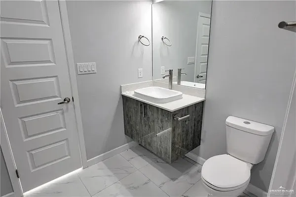 a bathroom with a sink a toilet and a mirror