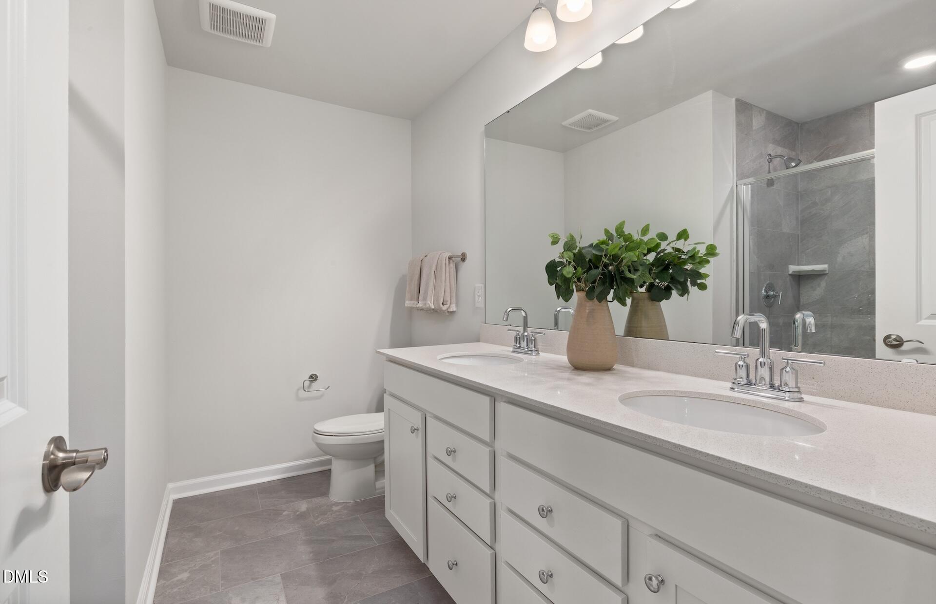 2818 Rodeo Court Fuquay-Varina, NC 27526 - Photo 18 of 30 a bathroom with a granite countertop sink a toilet and a large mirror