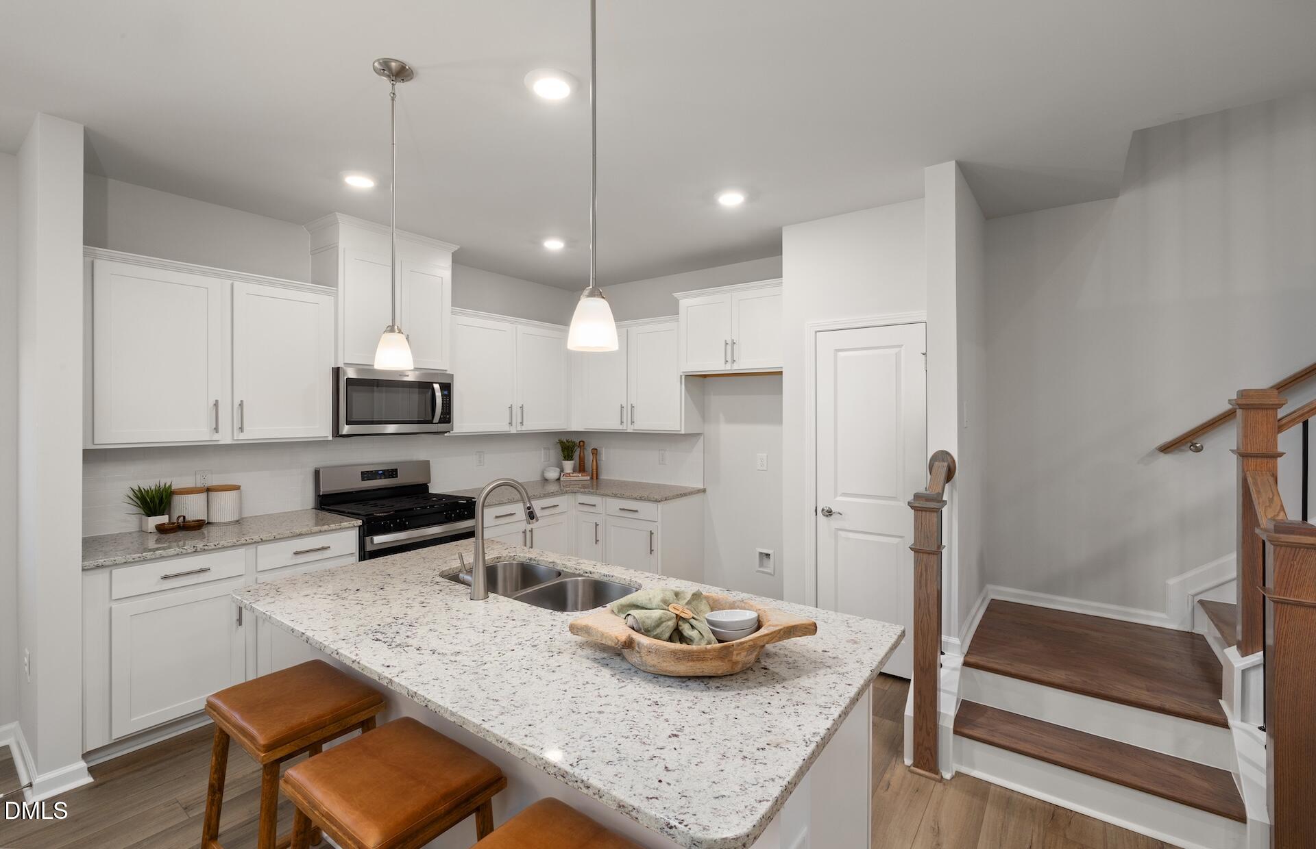 2818 Rodeo Court Fuquay-Varina, NC 27526 - Photo 6 of 30 a kitchen with stainless steel appliances granite countertop a sink stove and refrigerator