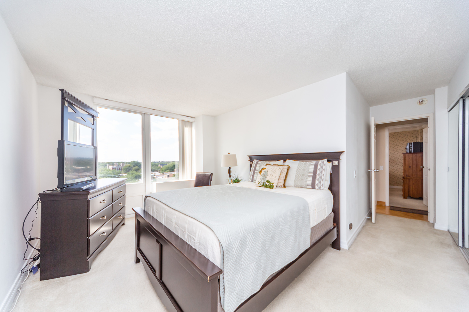 5320 North Sheridan Road, Unit 802 Chicago, IL 60640 - Photo 15 of 26 a large bed sitting in a large bedroom next to a window