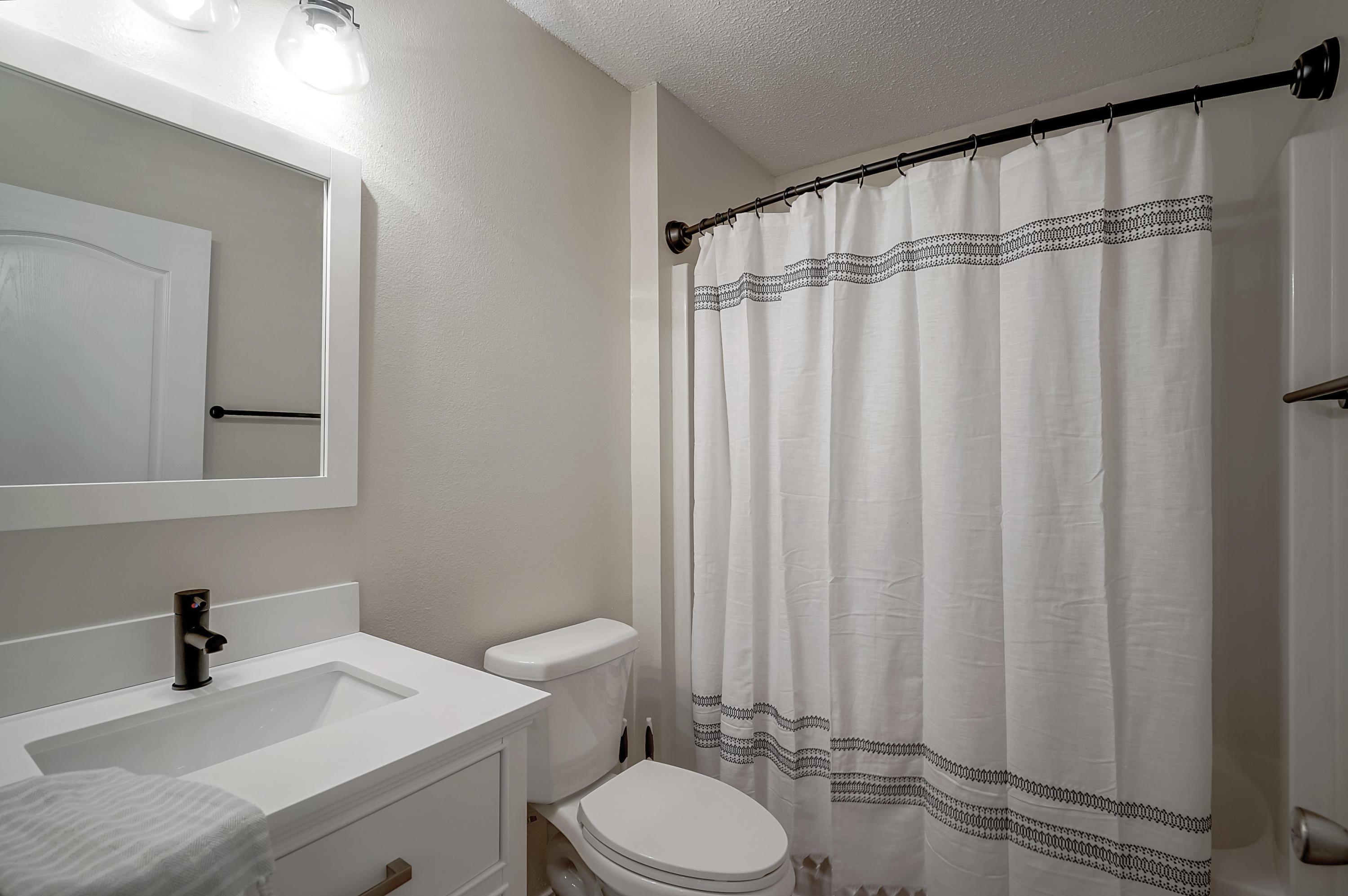5145 Eagle Way Crestview, FL 32539 - Photo 13 of 15 a bathroom with a sink a toilet and shower curtain
