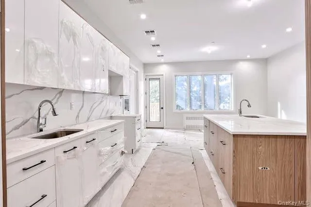 a large white kitchen with a large window