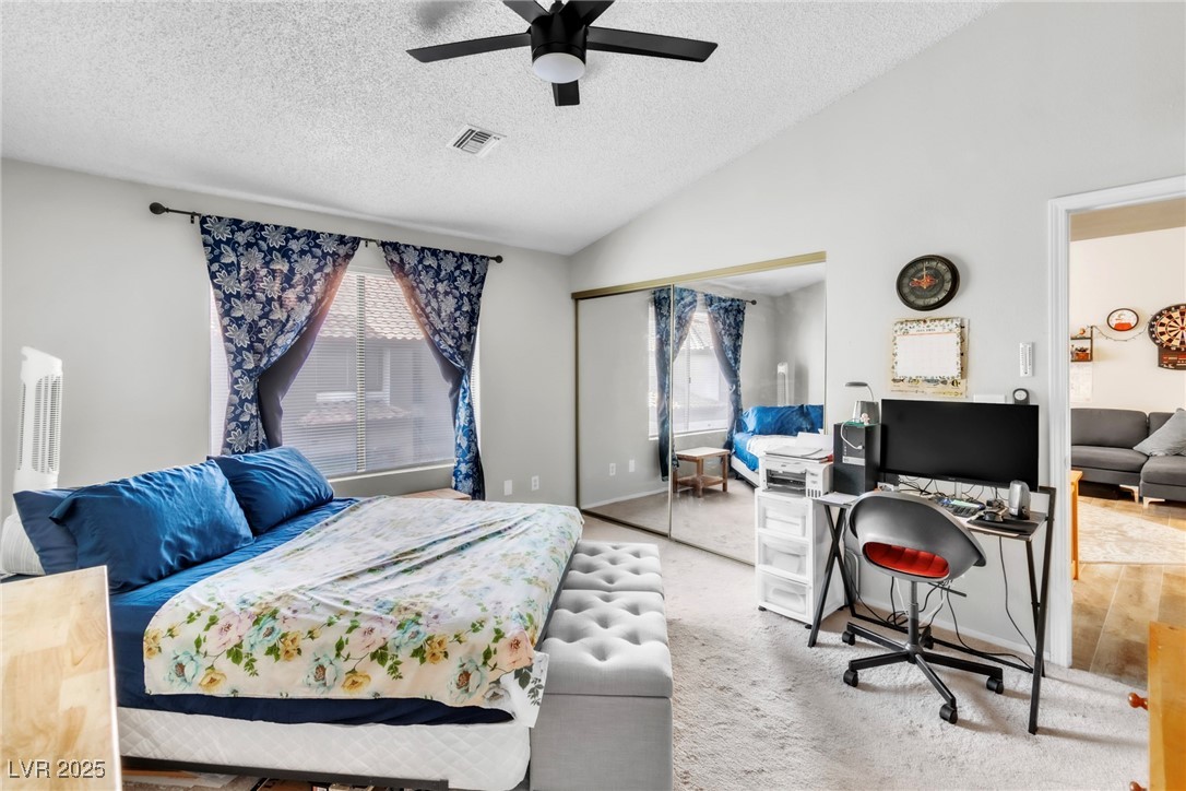 2995 East Sunset Road, Unit 235 Las Vegas, NV 89120 - Photo 13 of 24 Bedroom with vaulted ceiling, a textured ceiling, a closet, and ceiling fan
