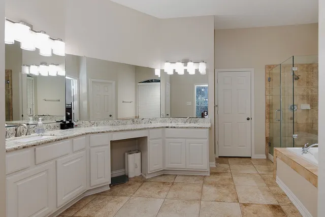 a spacious bathroom with a granite countertop sink a toilet a mirror a vanity and shower