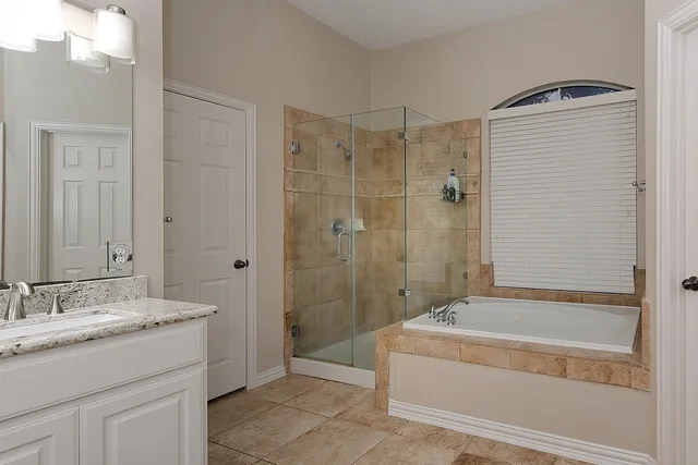 a bathroom with a granite countertop sink a toilet and shower