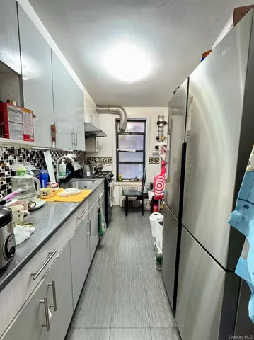 a kitchen with stainless steel appliances a refrigerator sink and wooden floor