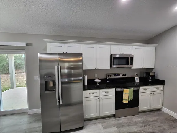 a kitchen with stainless steel appliances granite countertop a refrigerator and a stove