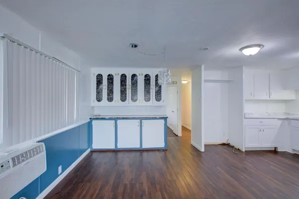 a kitchen with a wooden floor and white cabinets
