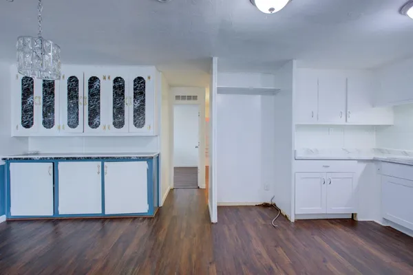 a kitchen with wooden floors and white cabinets