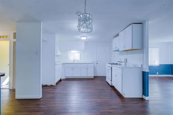 a kitchen with granite countertop white cabinets and white appliances