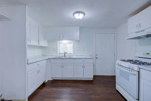 a kitchen with wooden floors and appliances