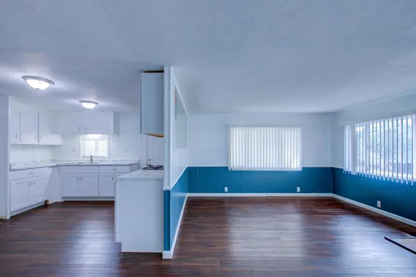 a kitchen with stainless steel appliances granite countertop a sink cabinets and wooden floor