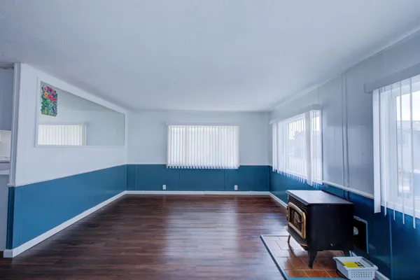 a room with wooden floor and windows