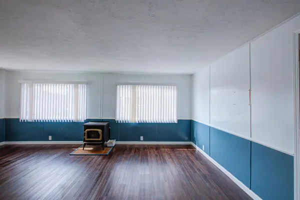 an empty room with windows and a fireplace