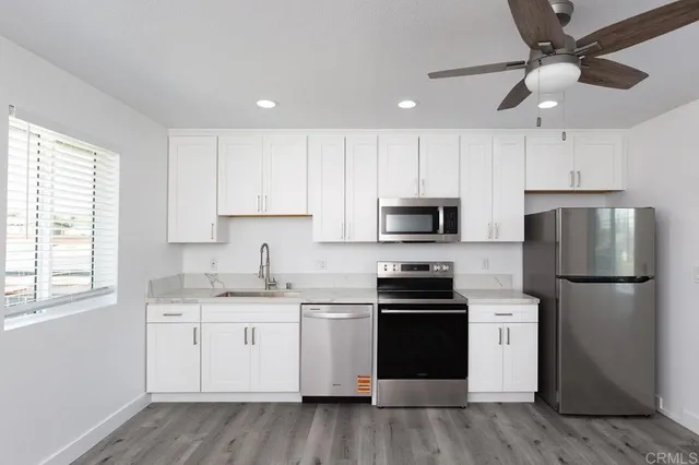 a kitchen with a sink a refrigerator a microwave and cabinets