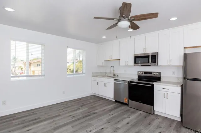 a kitchen with granite countertop stainless steel appliances cabinets a sink and a window