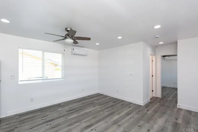 a view of a room with wooden floor and a ceiling fan