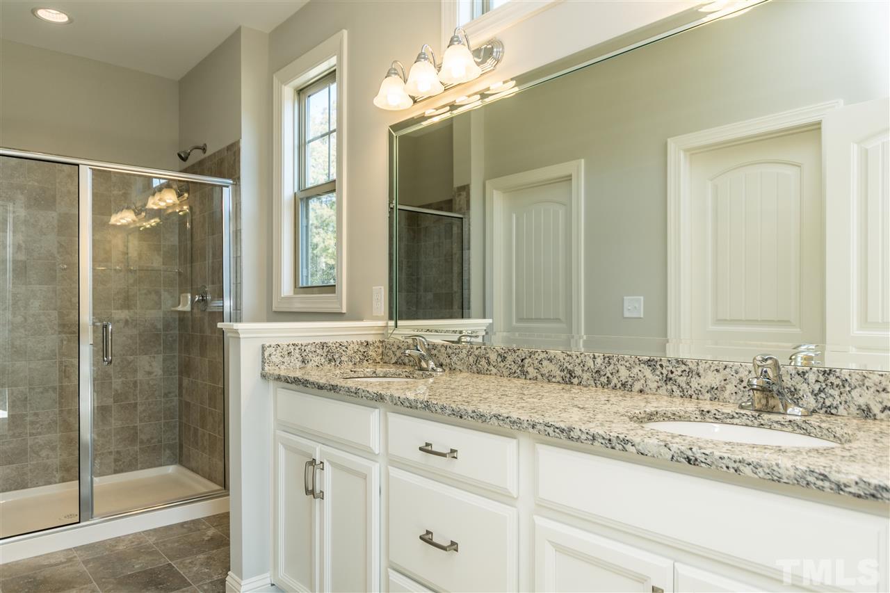 1505 Chestnut Falls Road Wendell, NC 27591 - Photo 16 of 25 Large walk-in closet, Upgraded tile in Large 6' walk in shower with a built in seat and beautiful granite vanity top accent the undermount sinks. Transom window and separate water closet are always nice features in any Owners Bath