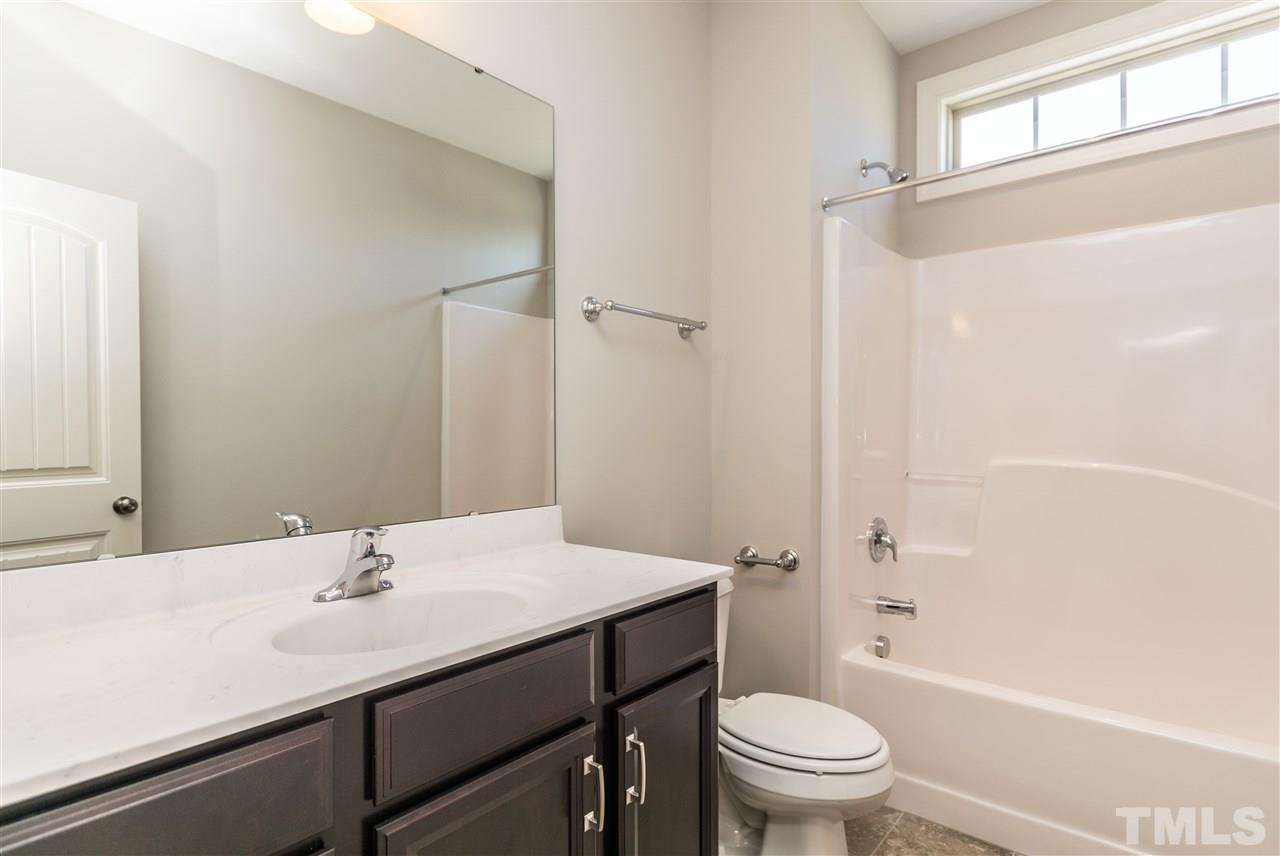 1505 Chestnut Falls Road Wendell, NC 27591 - Photo 18 of 25 Located on the 1st Floor next to the secondary bedroom. Oversized Adult height vanity with a Matte finished Cultured marble. Upgraded tile flooring and transom window.