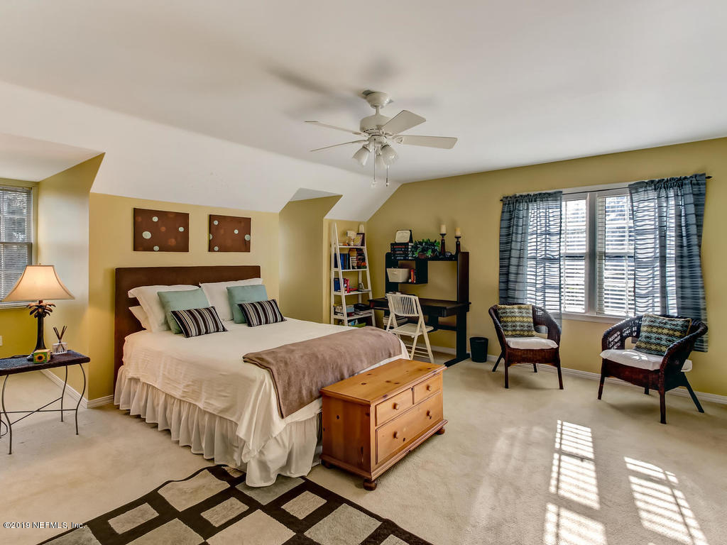 12200 Mandarin Road Jacksonville, FL 32223 - Photo 30 of 60 a bedroom with a bed a couch and a chandelier