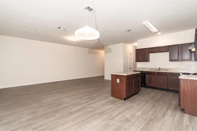 a kitchen with a sink cabinets and wooden floor