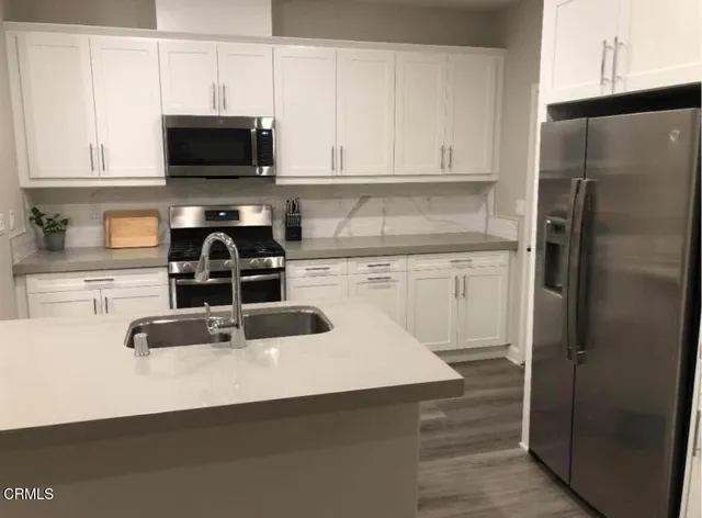 a kitchen with stainless steel appliances a refrigerator a stove a microwave and cabinets