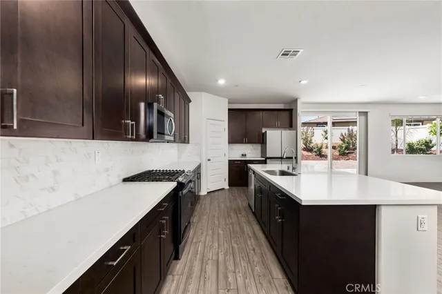 a kitchen with a stove and wooden floor