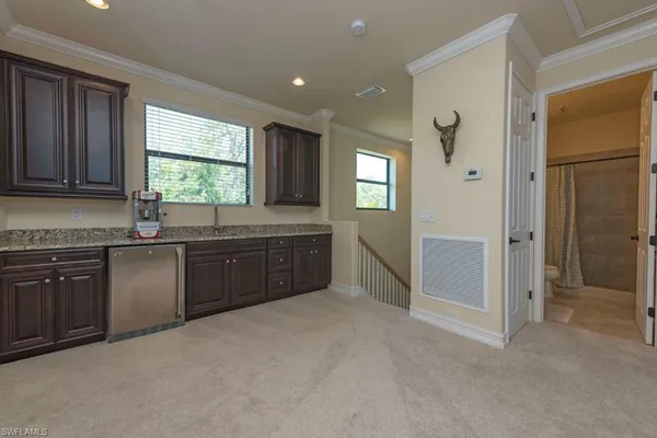 a kitchen with granite countertop a stove a sink and a refrigerator