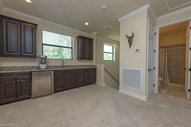 a kitchen with granite countertop a stove a sink and a refrigerator
