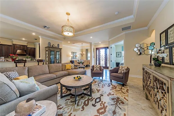 a living room with furniture kitchen view and a chandelier