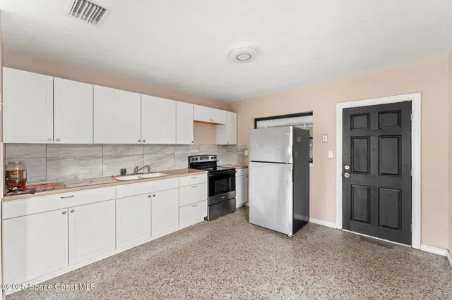 a kitchen with a refrigerator sink and cabinets
