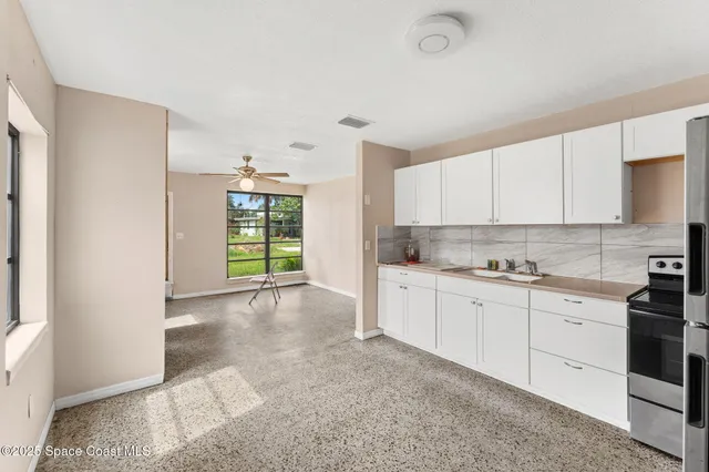 a kitchen with granite countertop white cabinets and white appliances