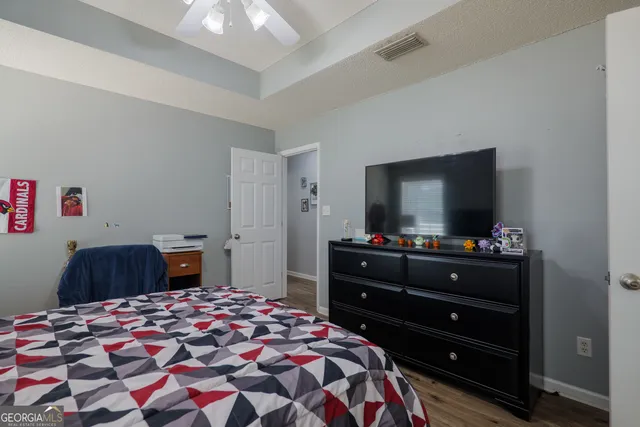a bedroom with a bed and a flat screen tv