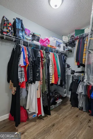 a view of walk in closet with clothes and shoes