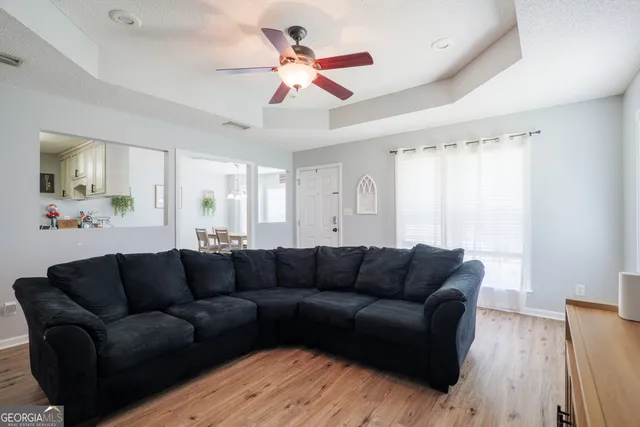 a living room with furniture and a ceiling fan