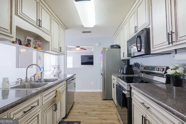 a kitchen with stainless steel appliances granite countertop a sink stove and refrigerator