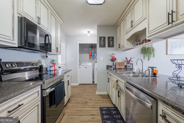 a kitchen with stainless steel appliances granite countertop lot of cabinets and wooden floor