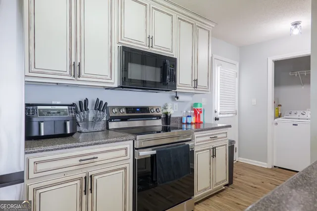 a kitchen with stainless steel appliances granite countertop a stove a microwave and cabinets