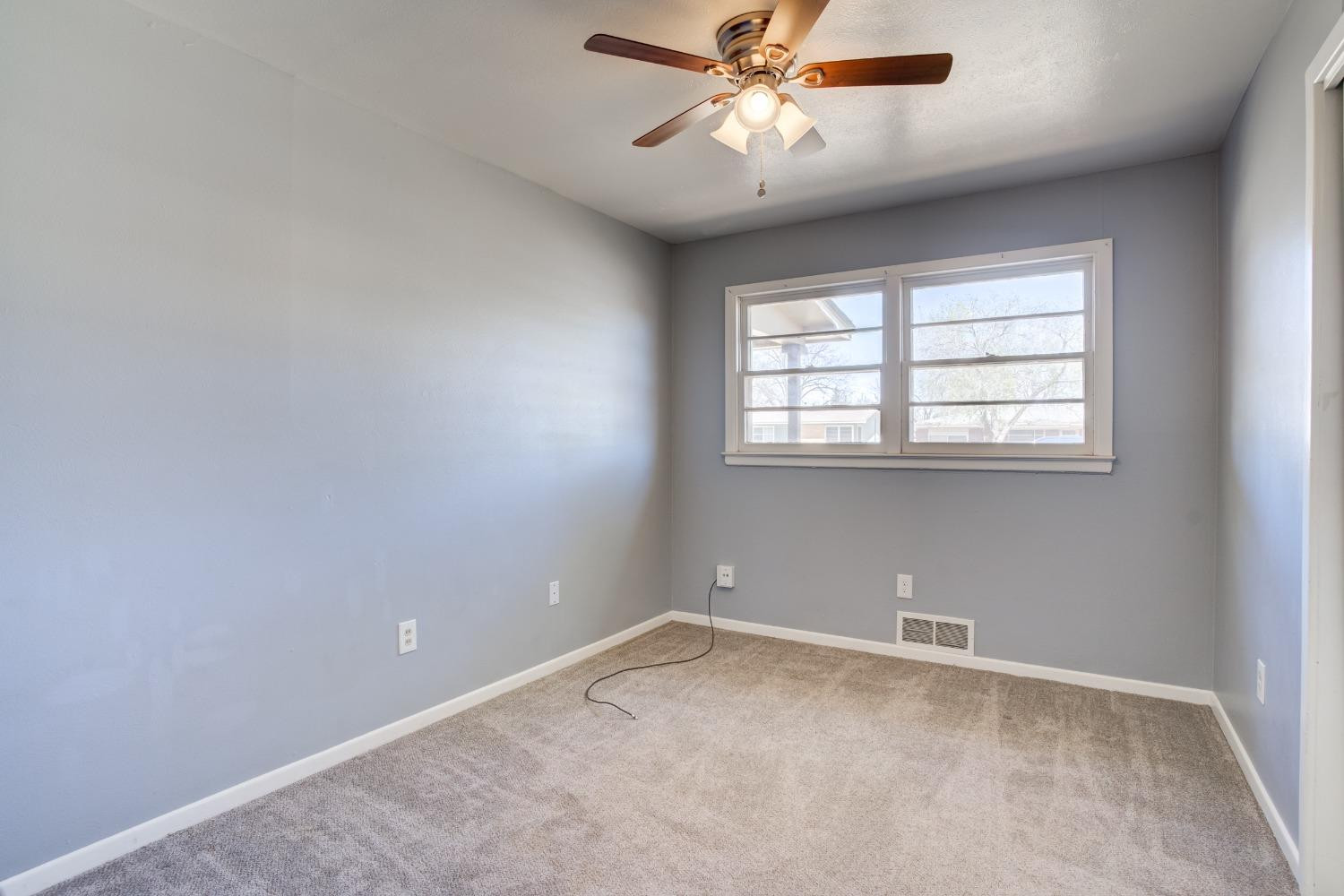 3011 44th Street Lubbock, TX 79413 - Photo 8 of 19 an empty room with a window and a fan