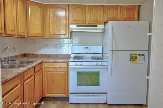 a kitchen with granite countertop cabinets stainless steel appliances and wooden floor