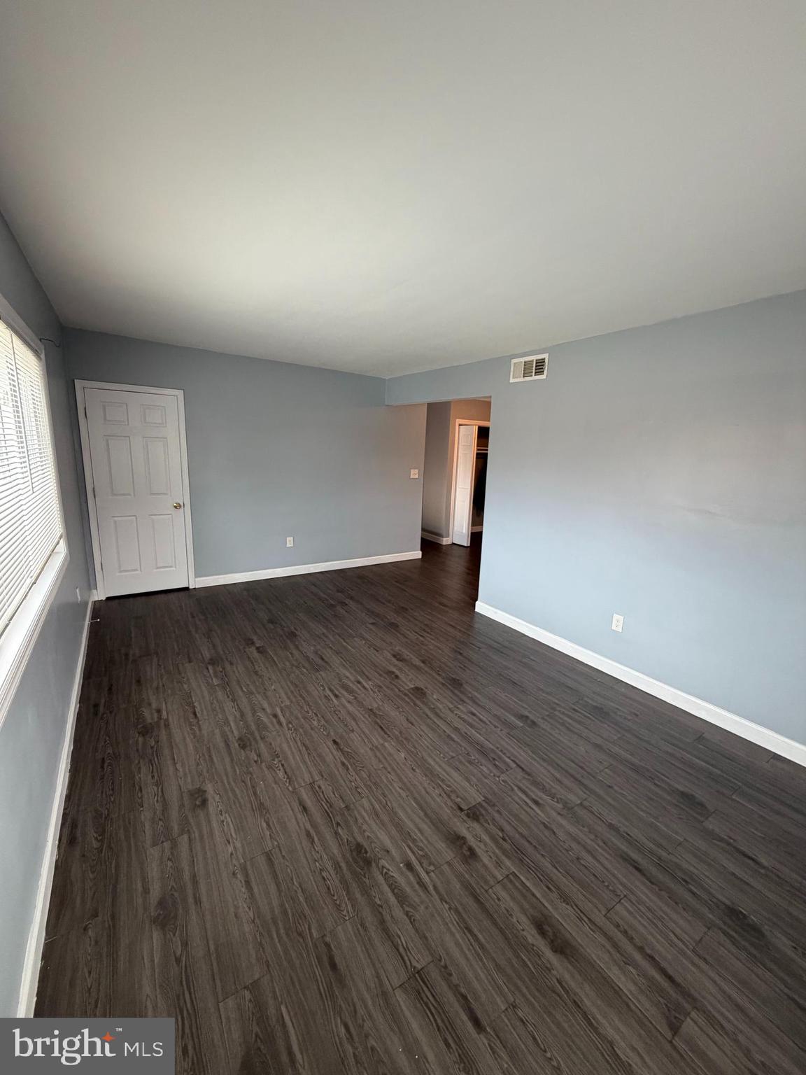 924 7th Street Laurel, MD 20707 - Photo 4 of 21 a view of an empty room with wooden floor and a window