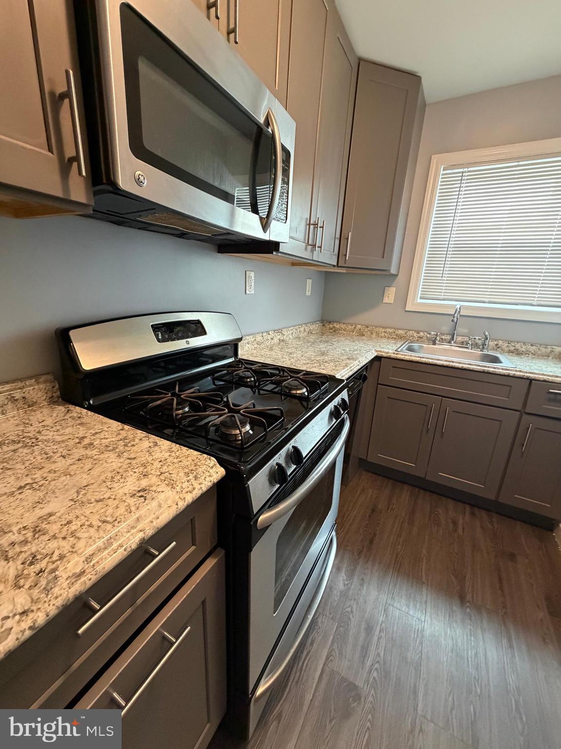 924 7th Street Laurel, MD 20707 - Photo 8 of 21 a kitchen with stainless steel appliances granite countertop wooden cabinets and a stove top oven