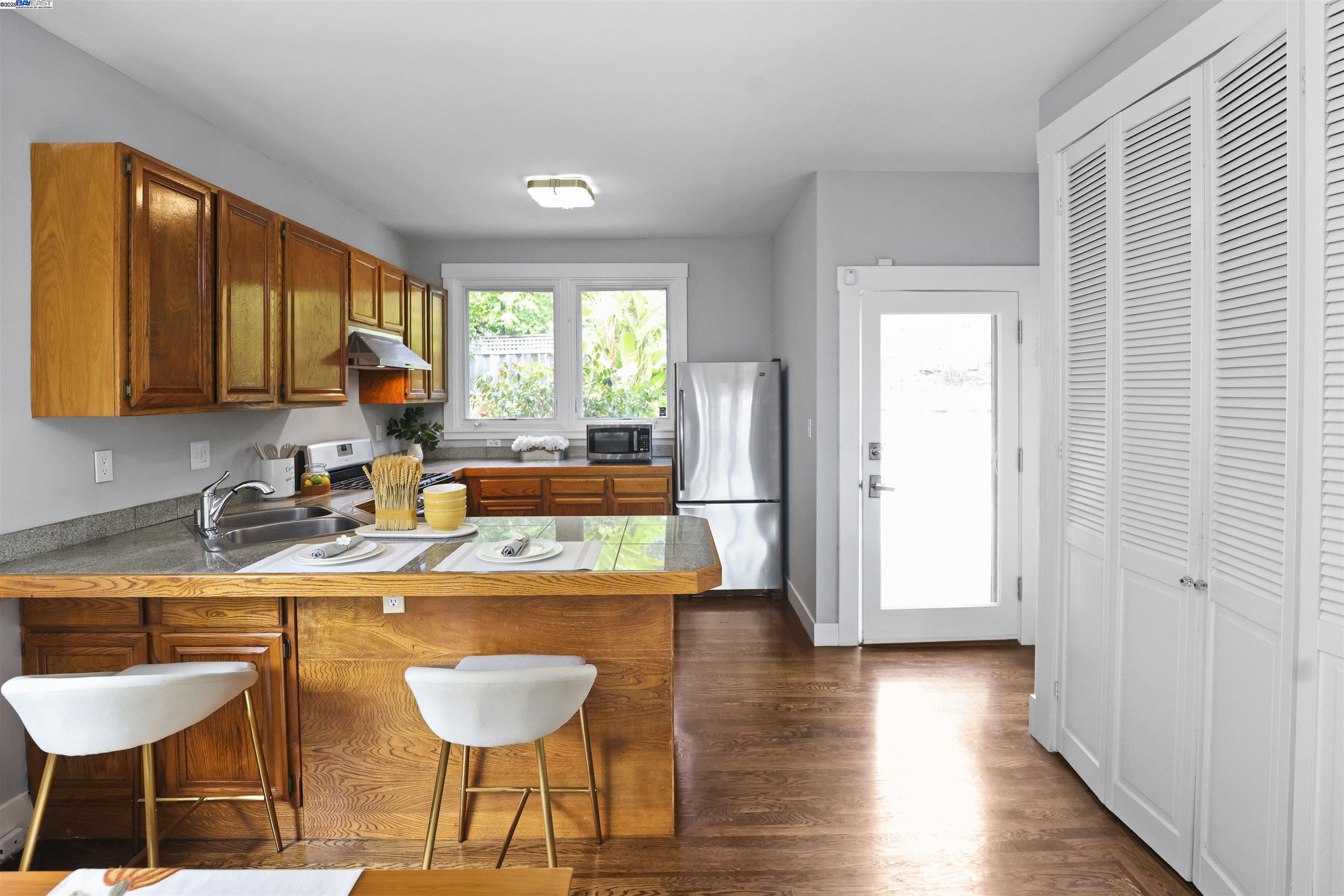 1361 Oakland Avenue Piedmont, CA 94611 - Photo 13 of 27 a kitchen with stainless steel appliances granite countertop a sink and a wooden cabinets