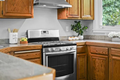 a kitchen with stainless steel appliances granite countertop a stove a sink and a refrigerator